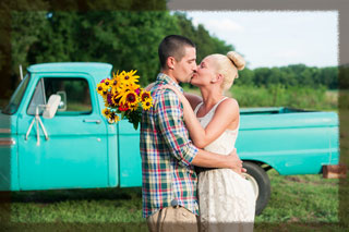 Amber and Brian kissing in front of truck
